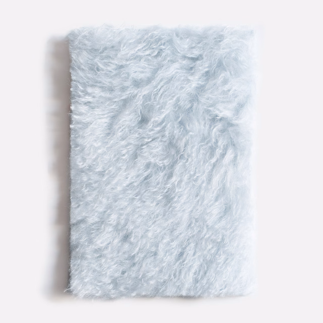 Pale icy-blue shaggy velvet swatch with curly pile and white highlights