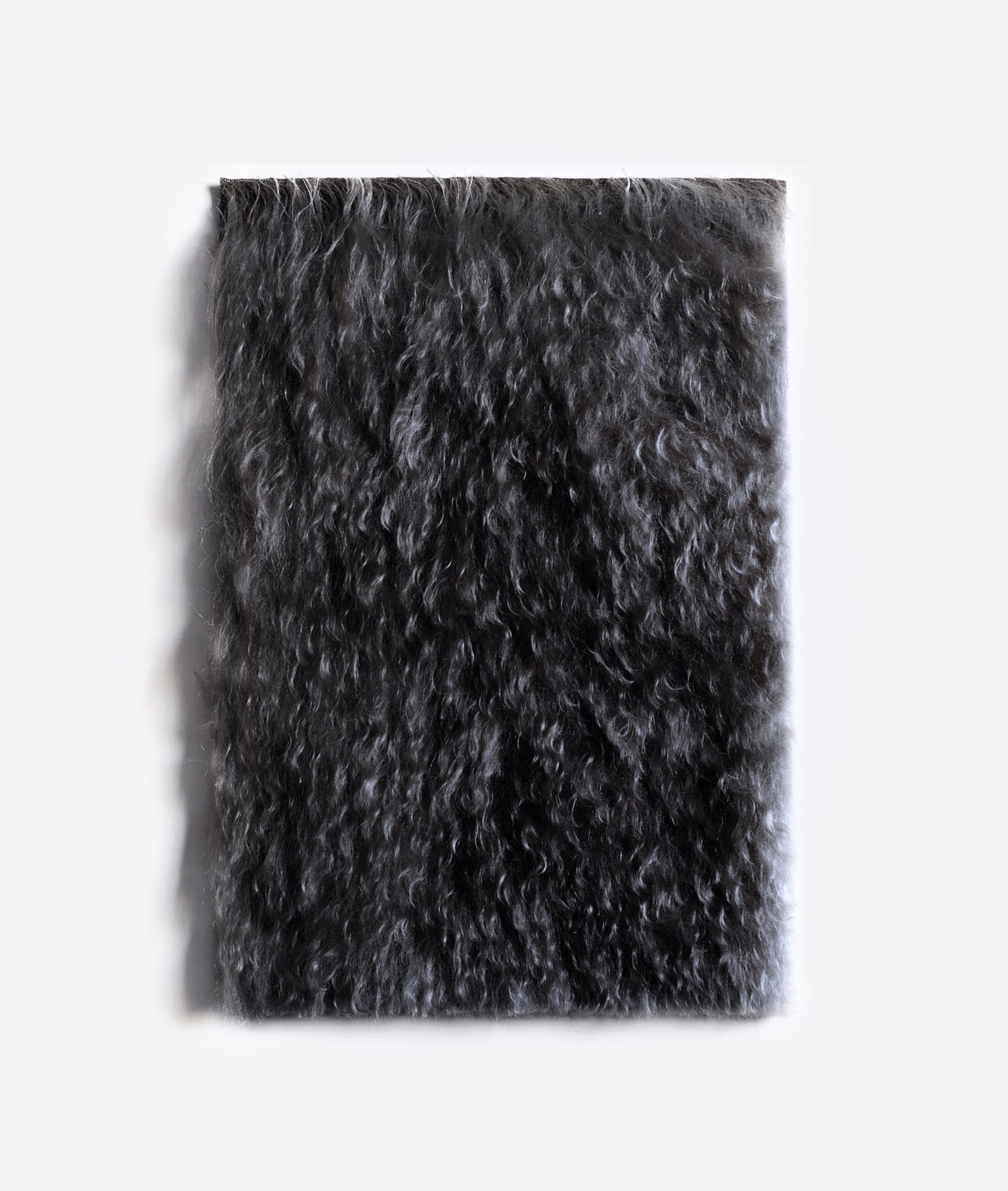 Deep charcoal-black velvet swatch with long irregular curls and a shadowed plush pile