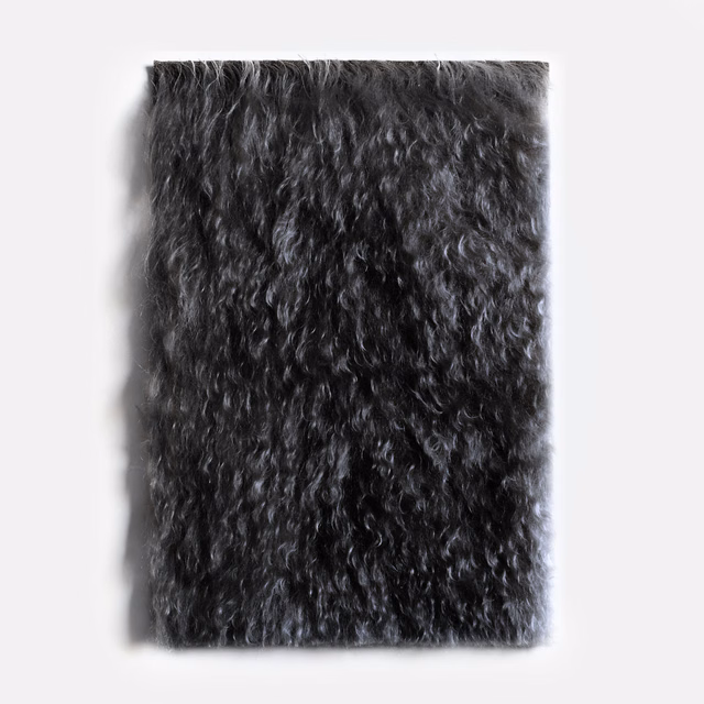 Deep charcoal-black velvet swatch with long irregular curls and a shadowed plush pile