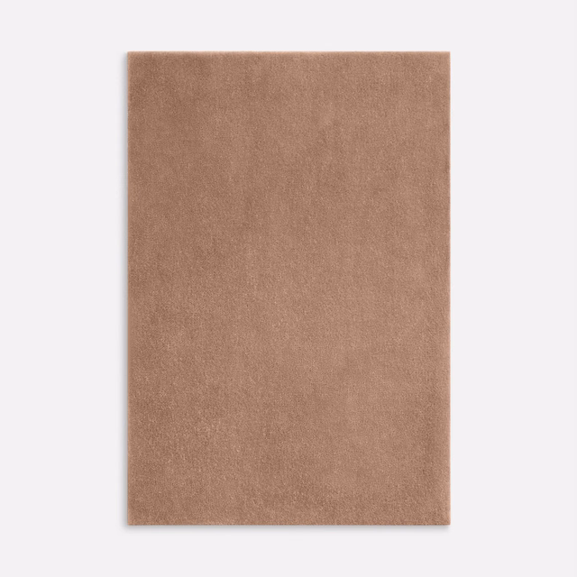 Close view of warm terracotta velvet with a softly shifting plain pile