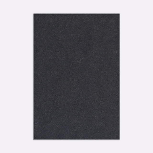 Close view of plain deep anthracite velvet with subtle directional nap and charcoal shading
