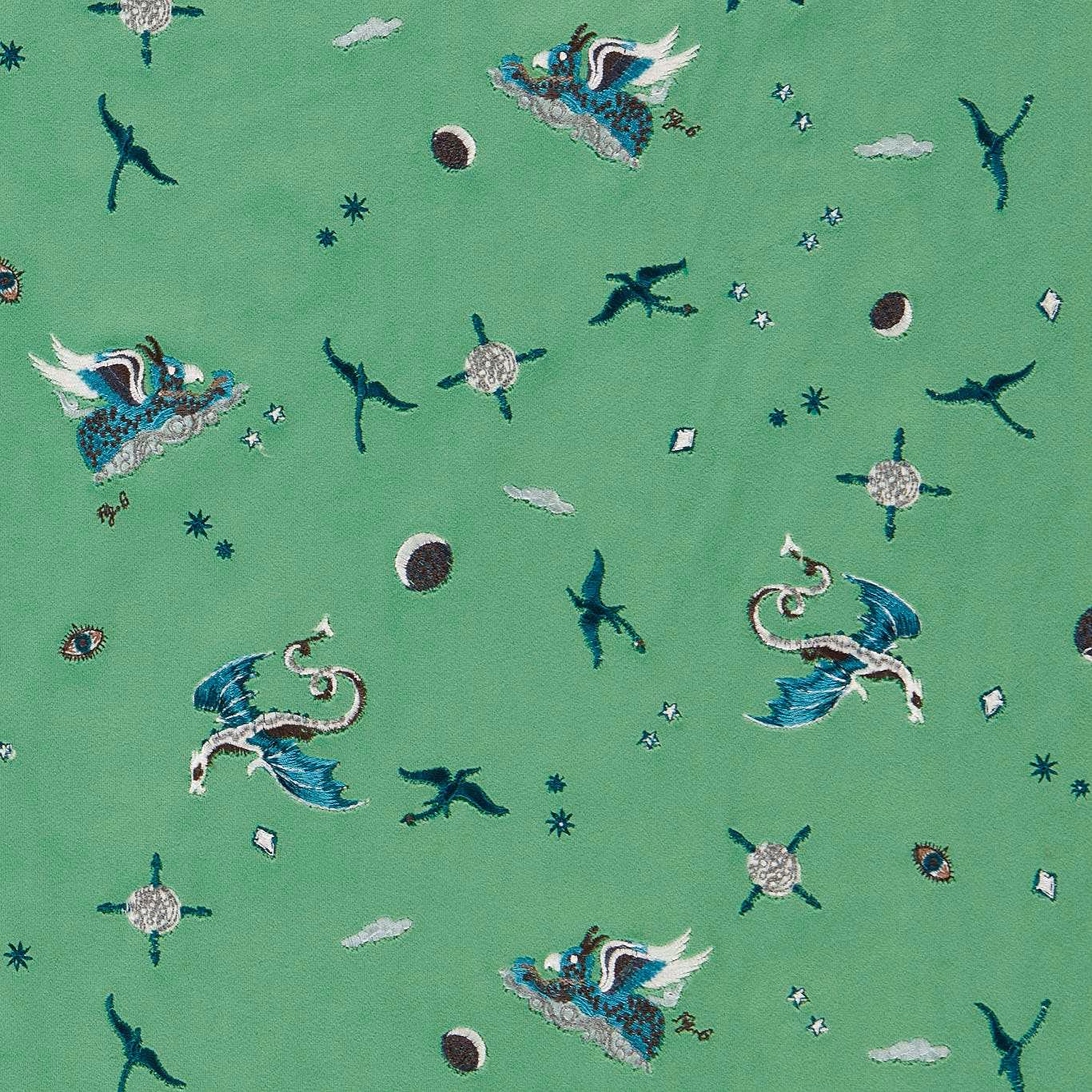 Jade green embroidered fabric with winged creatures, birds, moons and stars