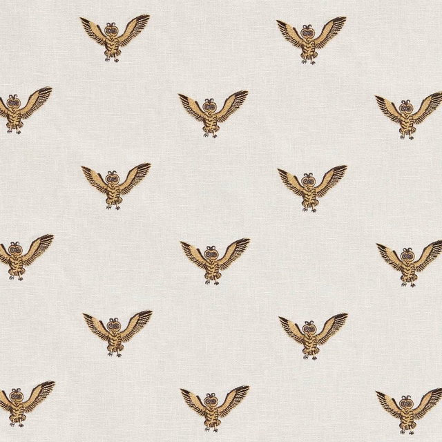 Ivory woven fabric with repeated gold-and-brown winged owl embroidery