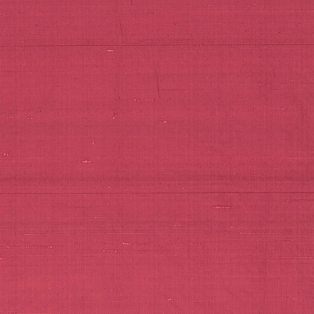 Close view of deep cardinal-red textile with fine horizontal slubs and woven grain