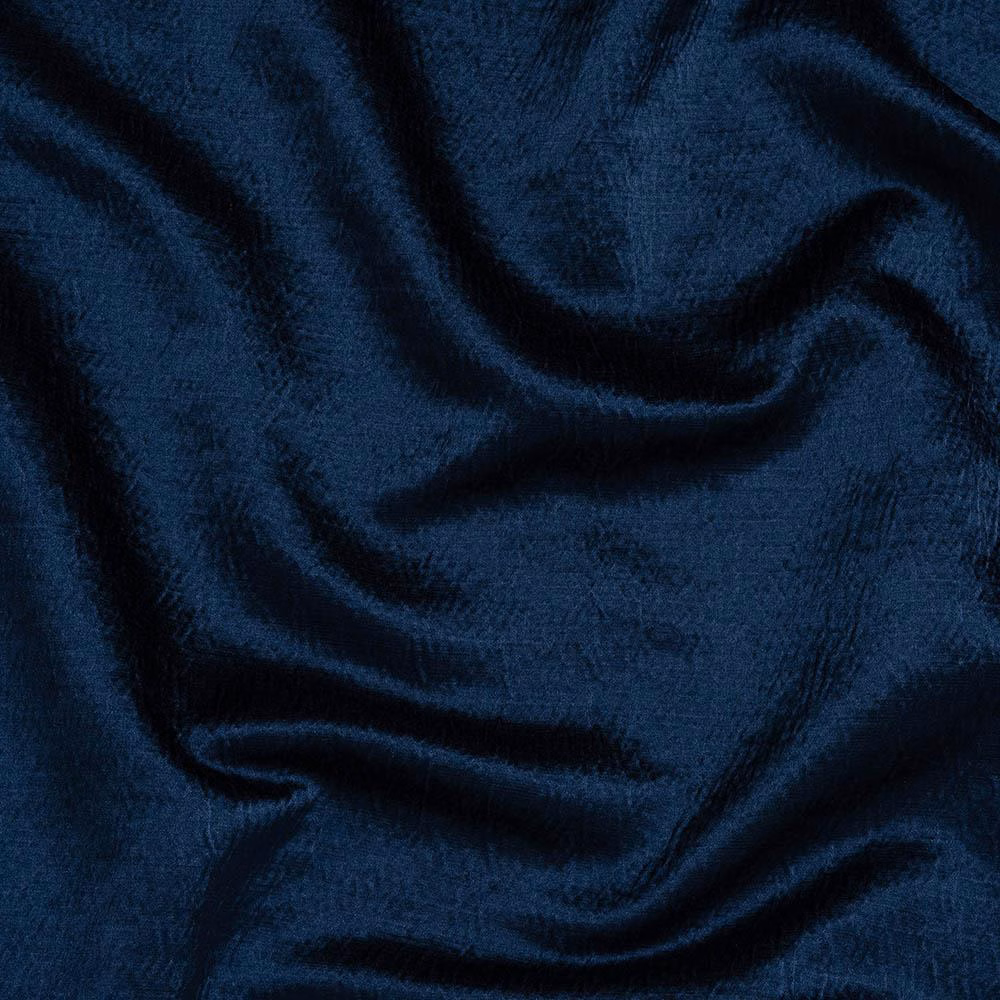 Deep indigo blue plain fabric with soft folds and a subtle woven sheen