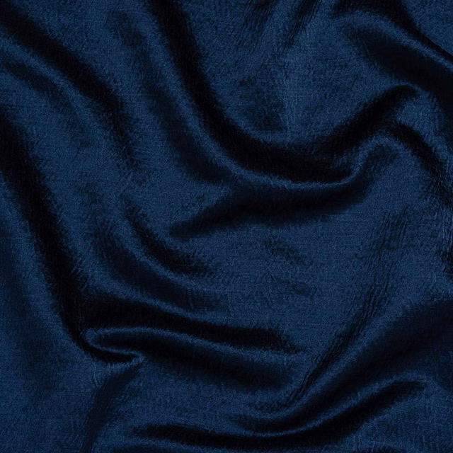 Deep indigo blue plain fabric with soft folds and a subtle woven sheen