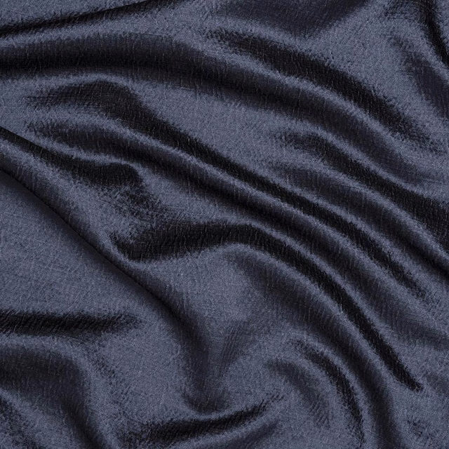 Close-up of deep navy woven fabric with soft lustre and rippling folds