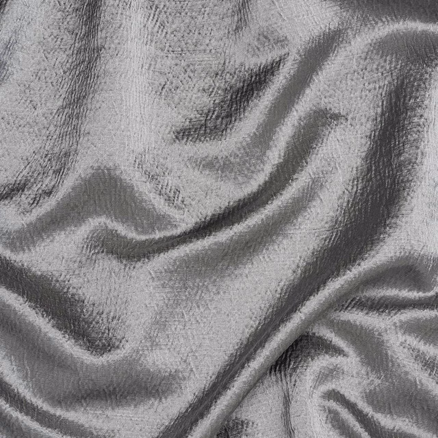 Shimmering silver-grey fabric with crumpled texture and darker shadowed folds