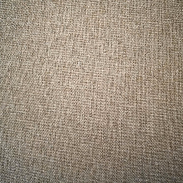 Close-up of soft beige textured plain weave fabric swatch
