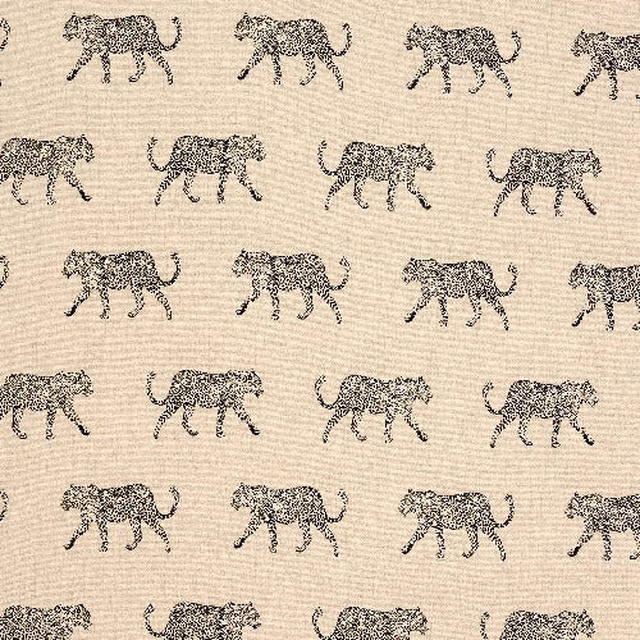 Warm cream cotton fabric with small dark leopard motifs in neat rows