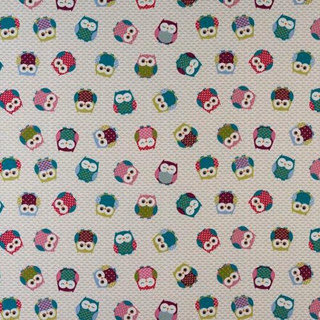 Close-up of multicolour owl print on a pale cotton fabric ground