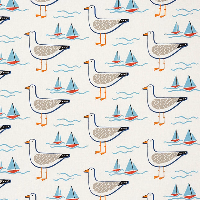 Cream cotton fabric with gulls, sailboats and wave motifs in navy, coral and turquoise