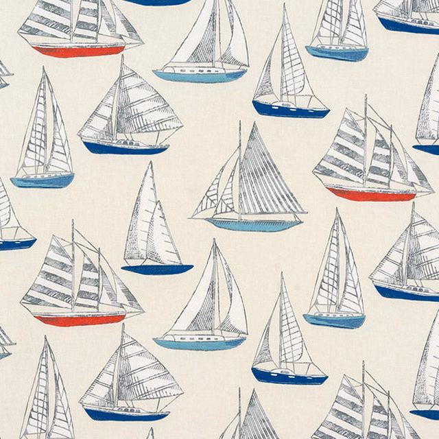 Cream cotton fabric printed with small sailing yachts in blue, grey and red