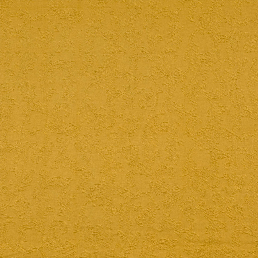 Muted mustard-gold textured fabric with embossed scrolling pattern