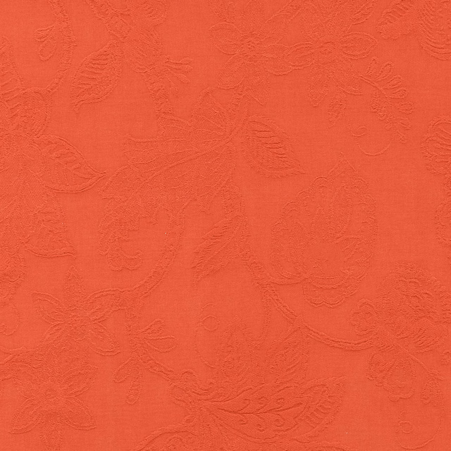 Coral orange floral jacquard fabric with raised textured leaves and vines