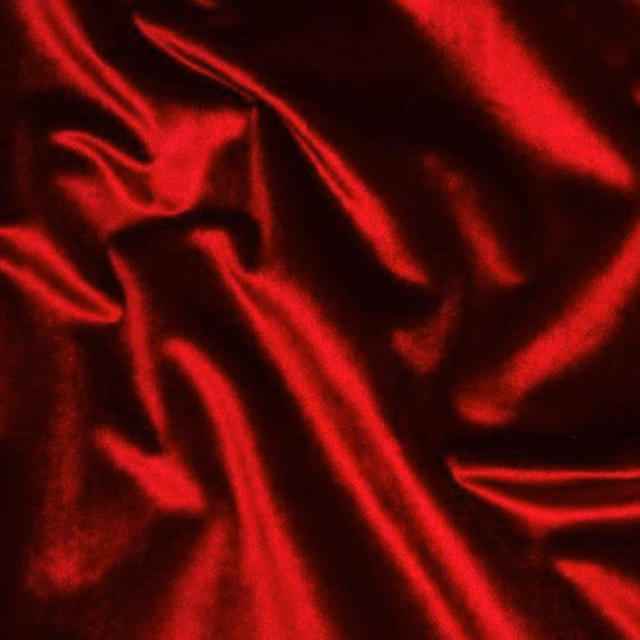 Shiny deep cranberry red fabric with soft folded ripples and glossy highlights