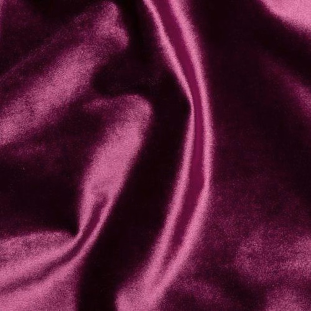 Close-up of deep plum velvet with glossy folds and rich berry highlights