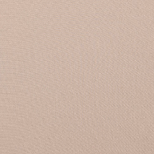 Close-up of soft caramel beige plain cotton fabric with fine weave texture