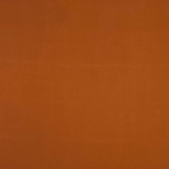 Close-up of plain rust-orange woven cotton fabric with fine texture