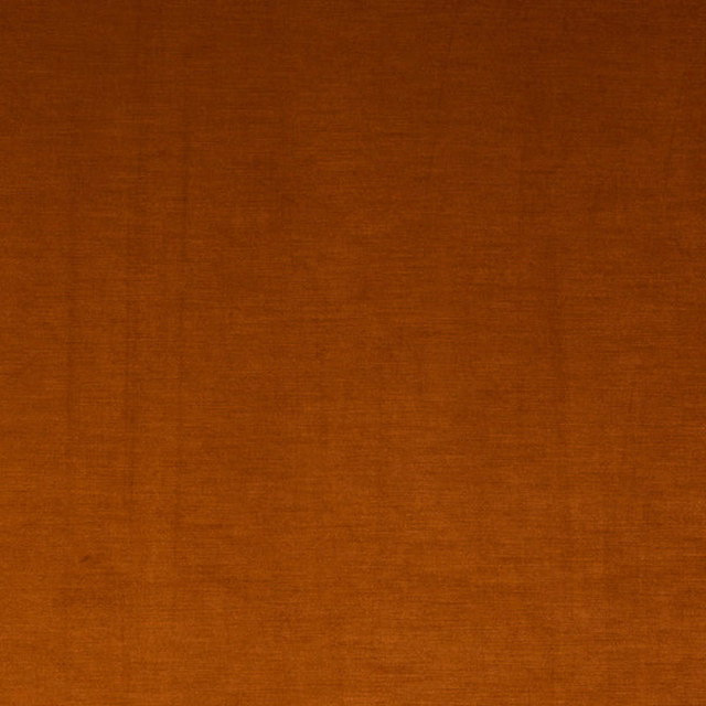 Plain burnt orange fabric swatch with a smooth woven texture and darker top edge