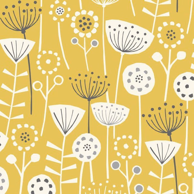 Ochre cotton fabric with scattered white and charcoal stylised floral motifs