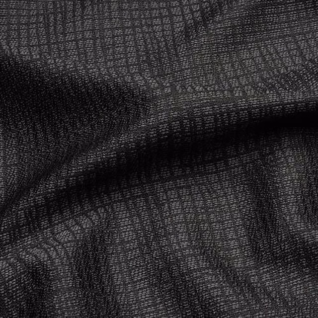 Close-up of charcoal grey woven fabric with a fine textured check pattern and soft folds.