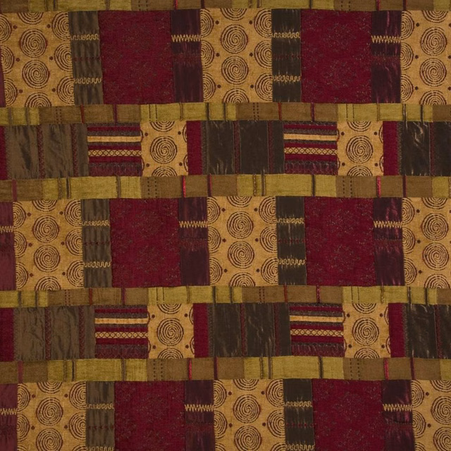 Patchwork patterned fabric swatch in plum, gold and olive tones with circular motifs