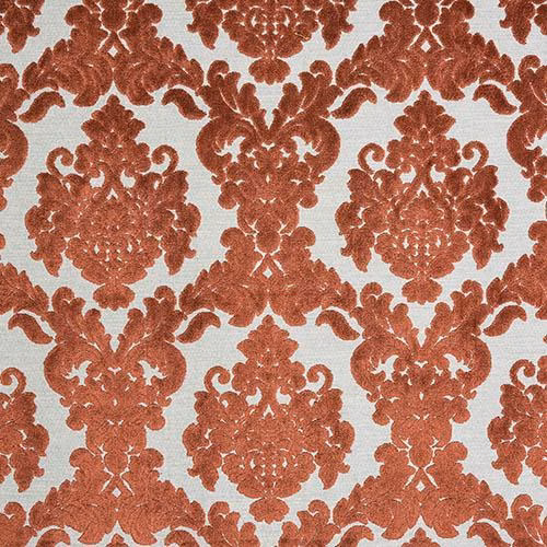 Burnt orange damask fabric on a pale ground with textured woven surface