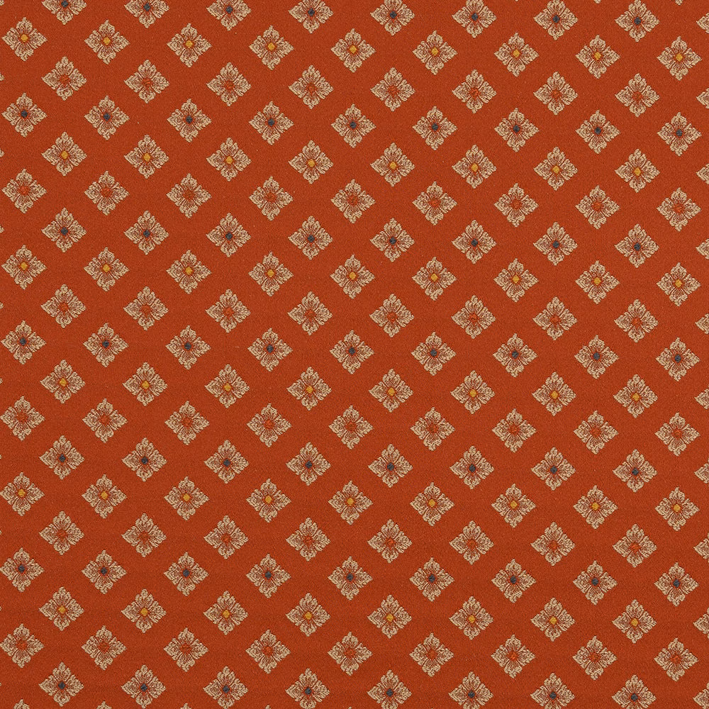 Terracotta fabric swatch with small cream diamond motifs and tiny multicolour centres