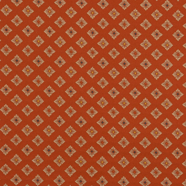 Terracotta fabric swatch with small cream diamond motifs and tiny multicolour centres