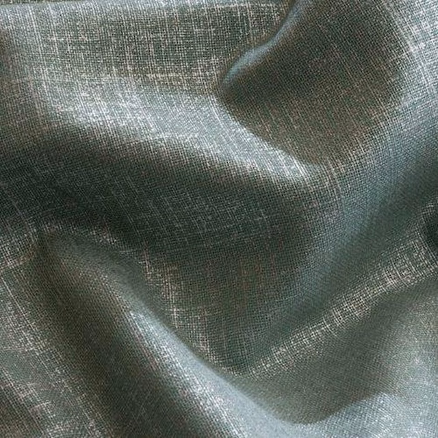 Soft sage-grey plain woven fabric with a fine linen texture and gentle folds