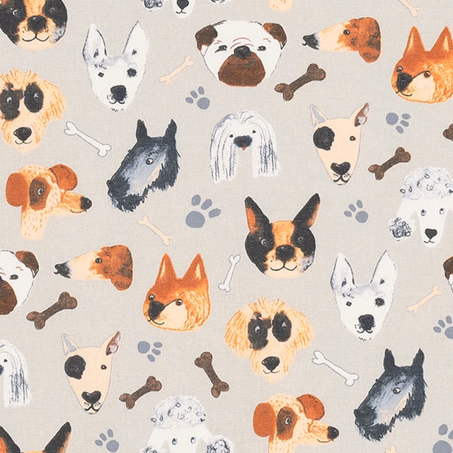 Cream cotton fabric printed with illustrated dog faces, bones and paw prints
