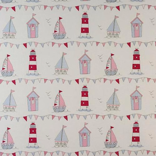 Pink seaside print with sailboats, lighthouses and bunting on a pale ground