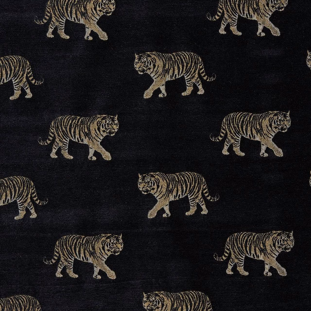 Black woven fabric with repeating golden tiger motif on a dark ground