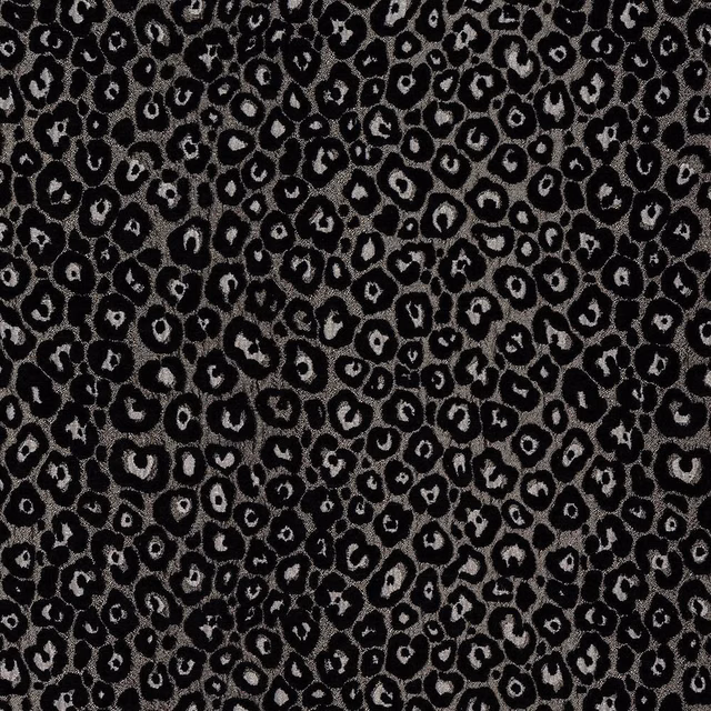 Close-up of black and smoky silver animal-print fabric with small irregular spots