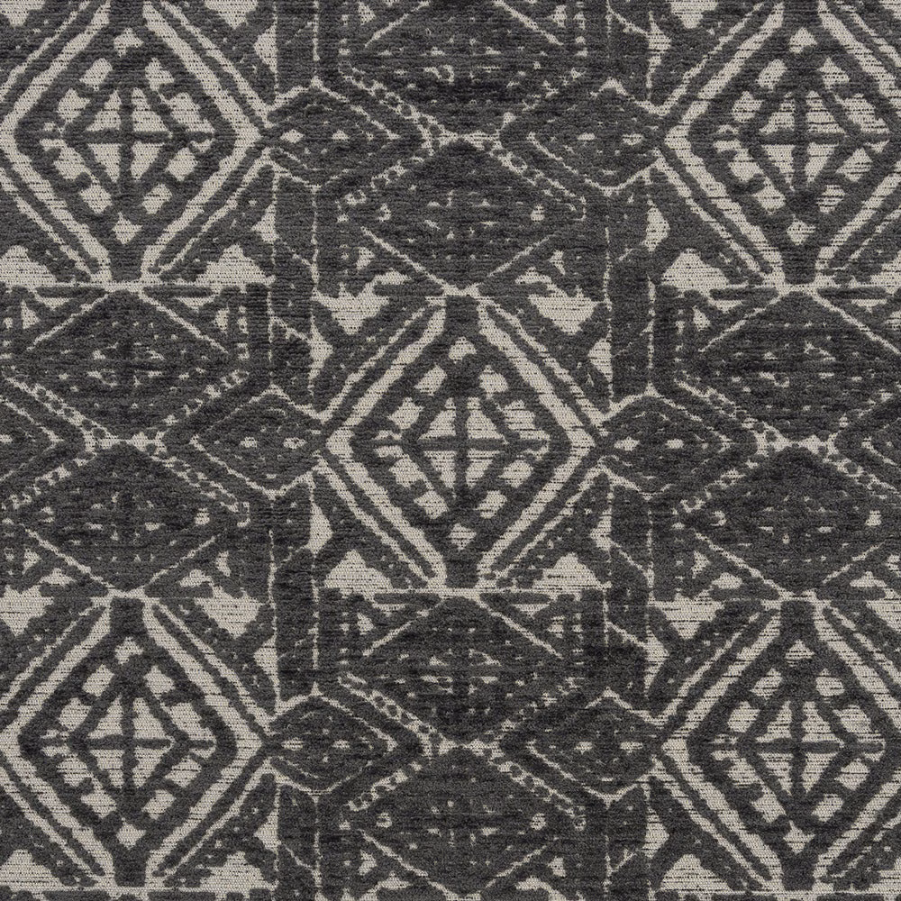Close-up of slate-grey geometric diamond fabric on a stone ground