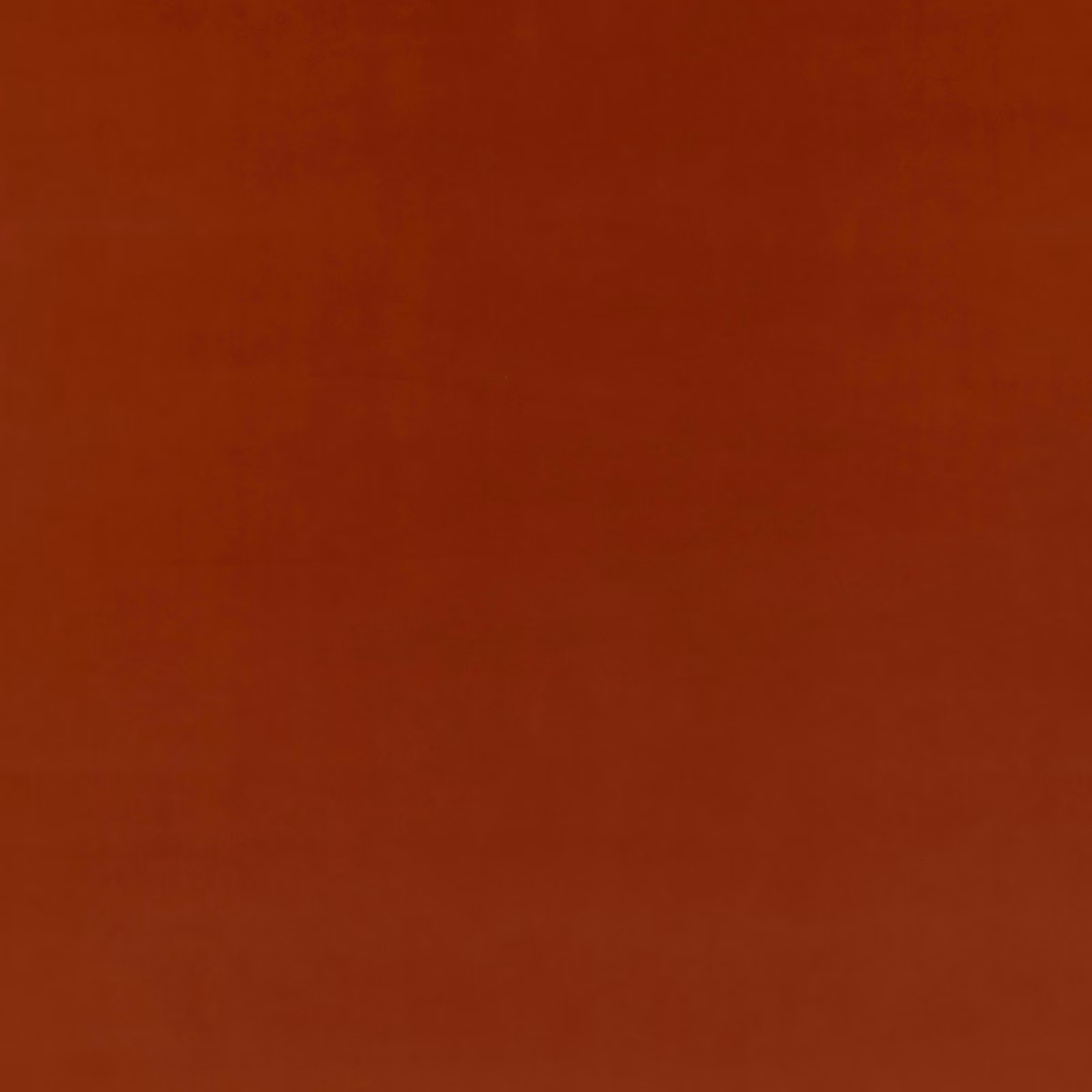 Close-up of plain rust-red velvet with soft nap and subtle coppery sheen