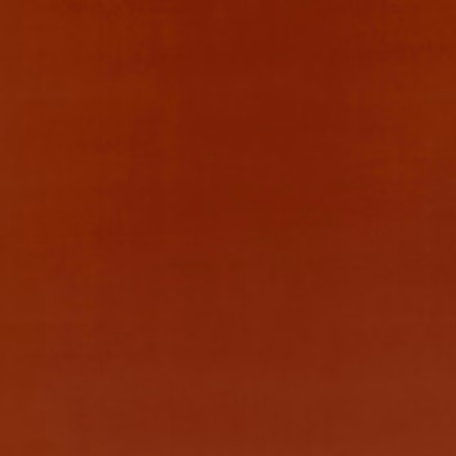 Close-up of plain rust-red velvet with soft nap and subtle coppery sheen