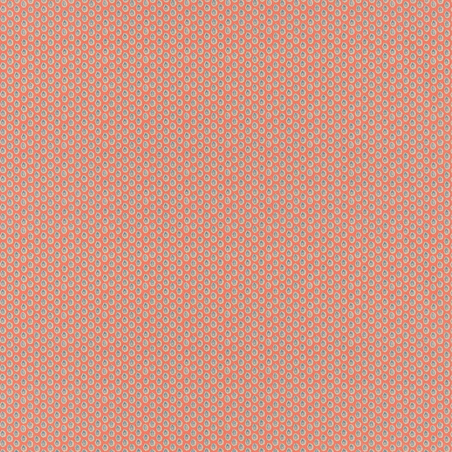 Coral red cotton with tiny blue-grey oval dot motifs in a dense repeat