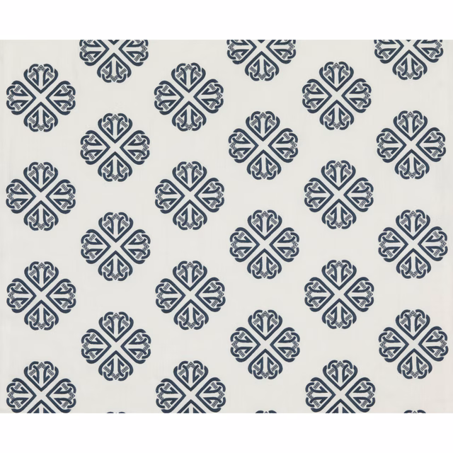 Cool indigo ornamental medallions repeating across a pale ivory textile ground