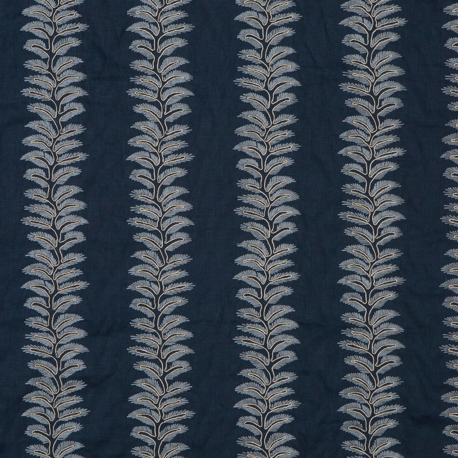 Deep indigo botanical fabric with repeating pale blue-grey leafy stems