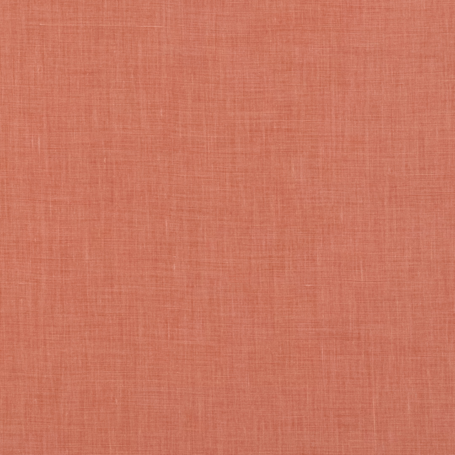 Close-up of muted coral linen with a fine, irregular crosshatch weave