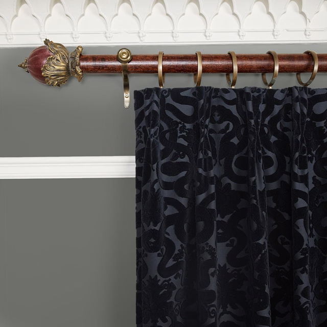 Near-black velvet curtain with tonal scrolling foliage and deep gathered folds