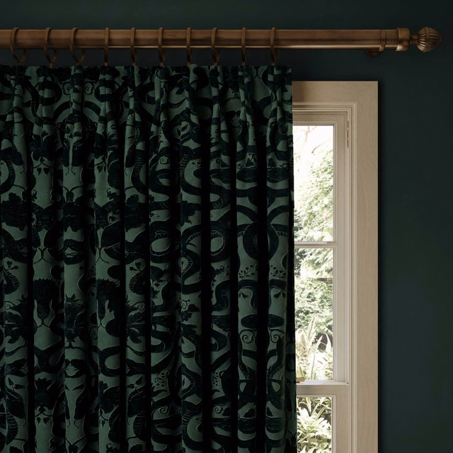 Deep petrol velvet curtain with black sinuous anaconda pattern in gathered folds