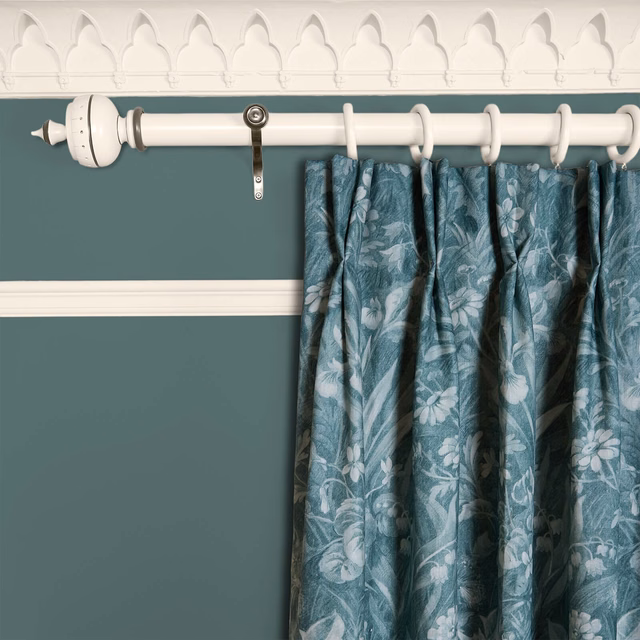 Muted teal curtain with pale botanical flowers and foliage in gathered folds