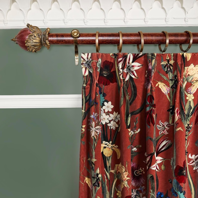 Gathered clay-red curtain with multicoloured trailing flowers and foliage