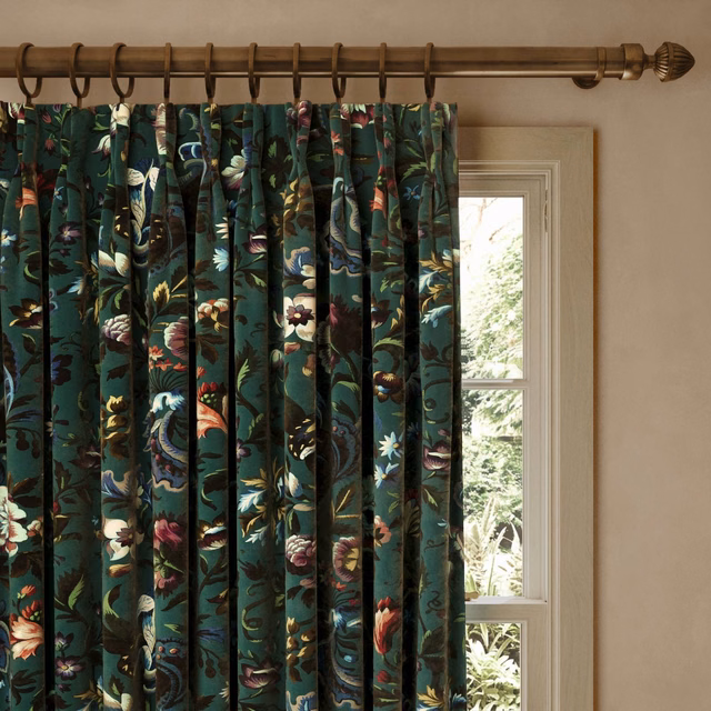 Deep petrol velvet curtain with colourful botanical flowers in full pleats