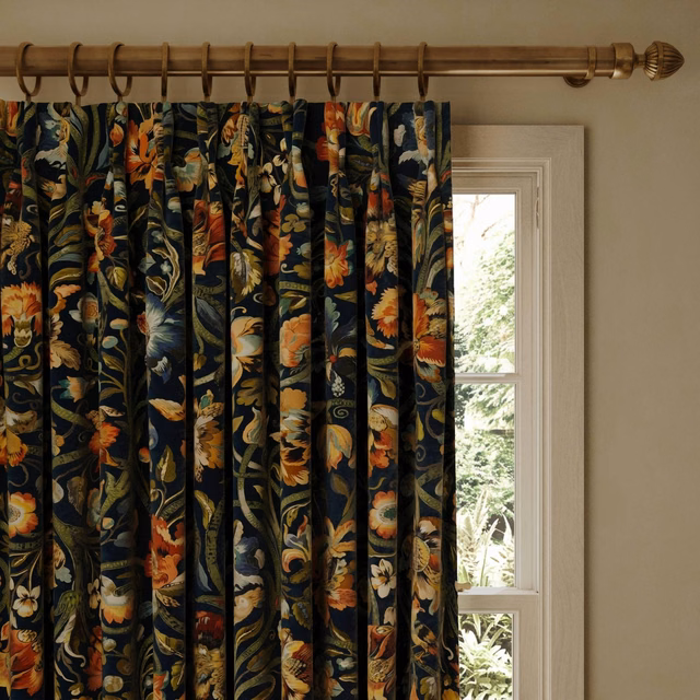 Midnight velvet curtains with orange and teal botanical blooms in deep folds