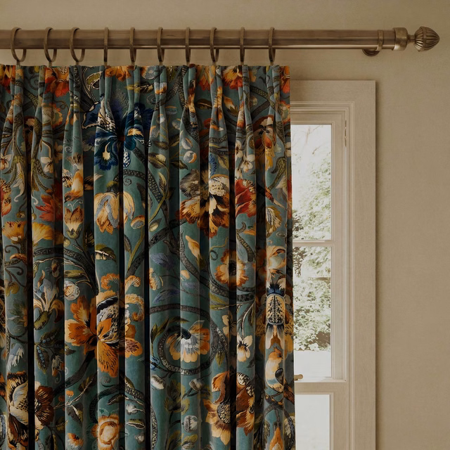 Prussian blue velvet curtain with teal folds and ochre botanical blooms