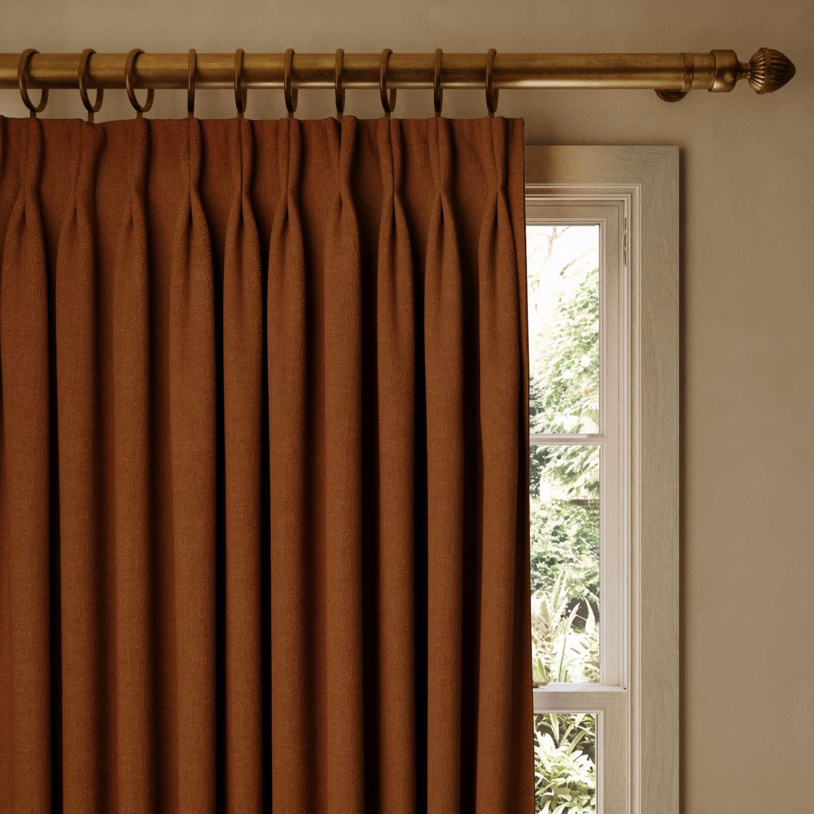Warm tobacco-brown curtain in deep vertical pleats beside a bright window